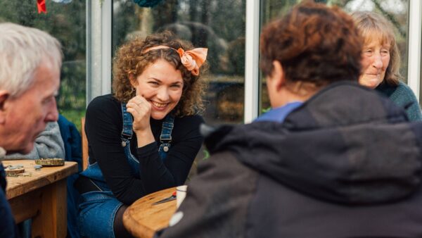 A group of people gather around a table to chat