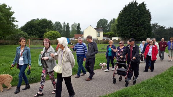 Group of older people walking on a path together and chatting