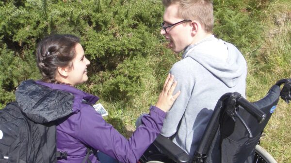 Boy in wheelchair takes part in a sensory story outside