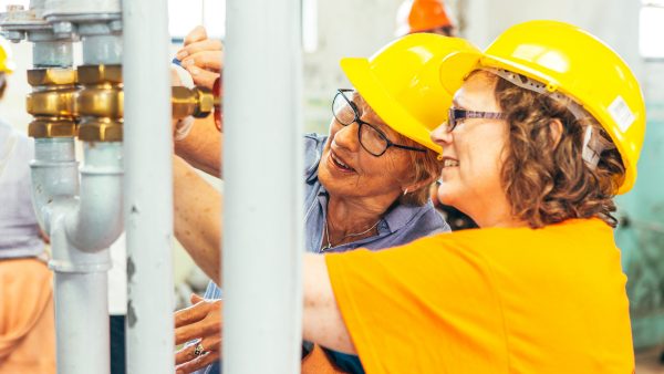 Two women in hard hats explore the workings of Geevor mine