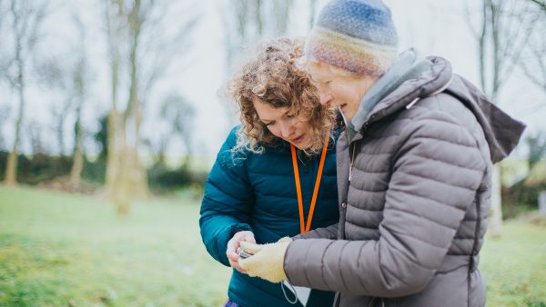 Sensory Trust activity group member and staff doing a nature activity