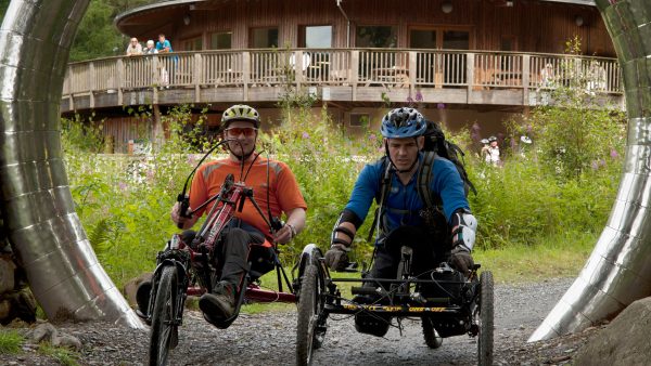 Two cyclists using wheelchair-adapted bikes