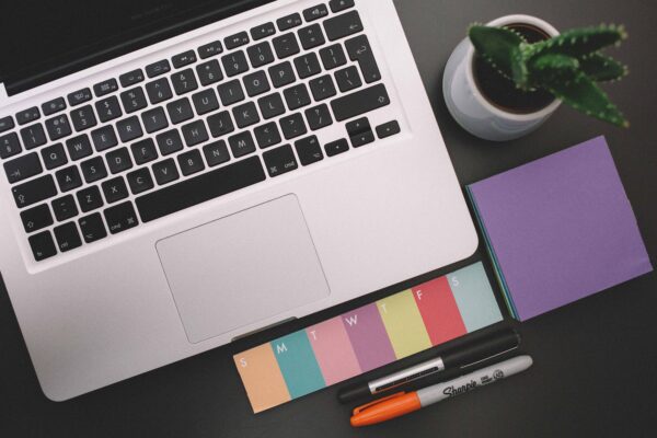 Looking down on a desk with laptop and pens