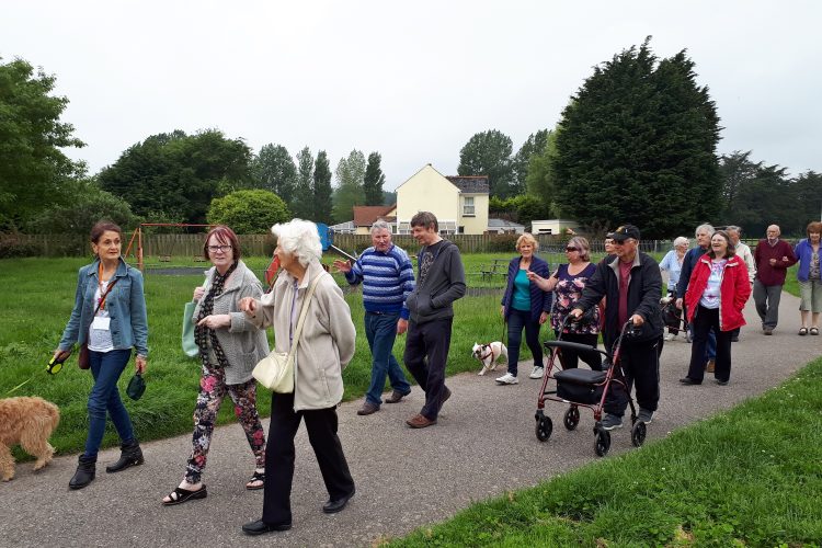 Group of older people walking on a path together and chatting