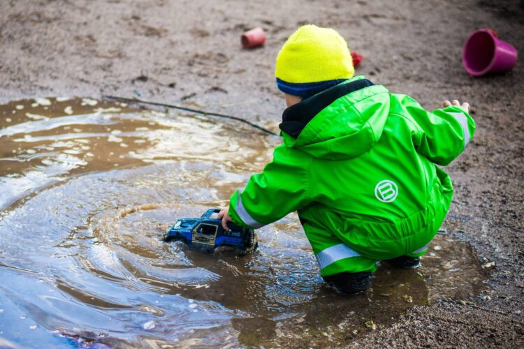 Young child having fun with a puddle