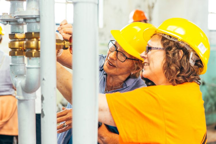 Two women in hard hats explore the workings of Geevor mine