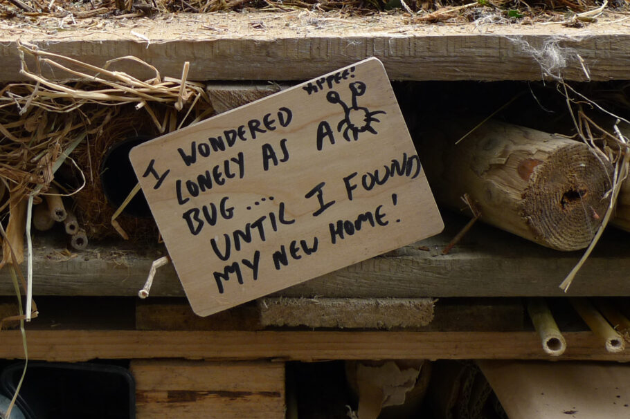 Written sign on a bug hotel says "I wandered lonely as a bug until I found my new home"