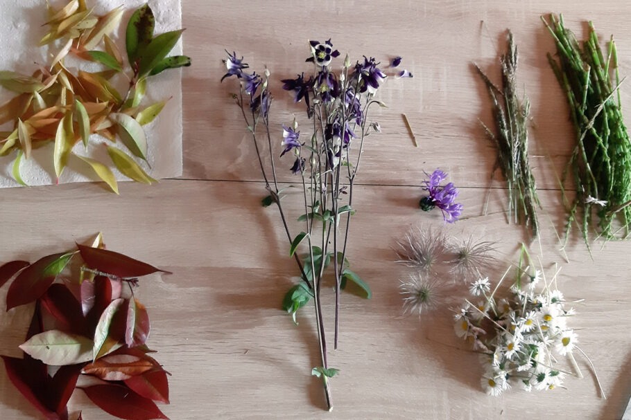 A collection of cut flowers and leaves ready for crafting
