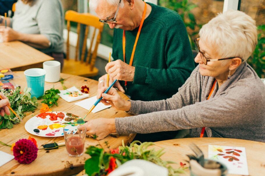 Two older taking part in a painting activity at Potager gardens