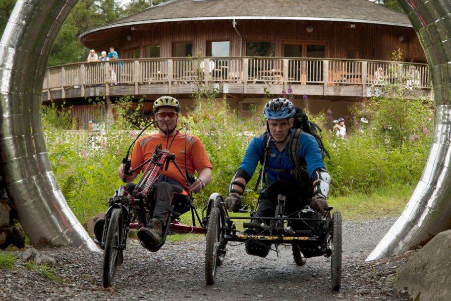 Two cyclists using wheelchair-adapted bikes